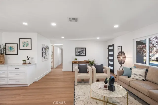 a living room with furniture and a wooden floor