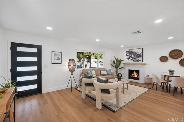 a living room with fireplace furniture and wooden floor
