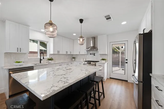 a kitchen with a table chairs and white cabinets