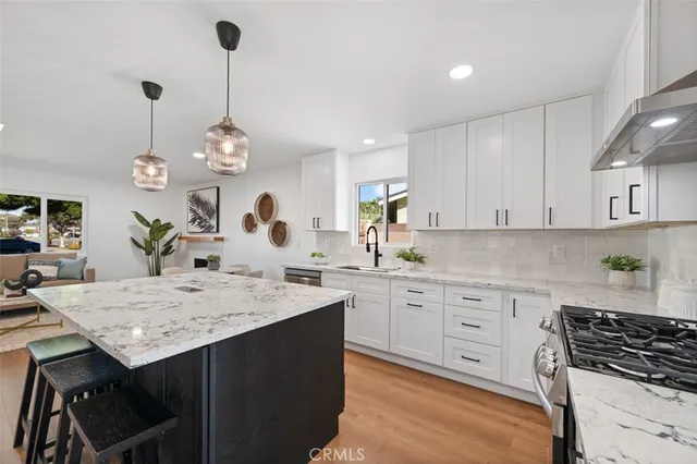 a kitchen with stainless steel appliances granite countertop a sink dishwasher a stove and a refrigerator