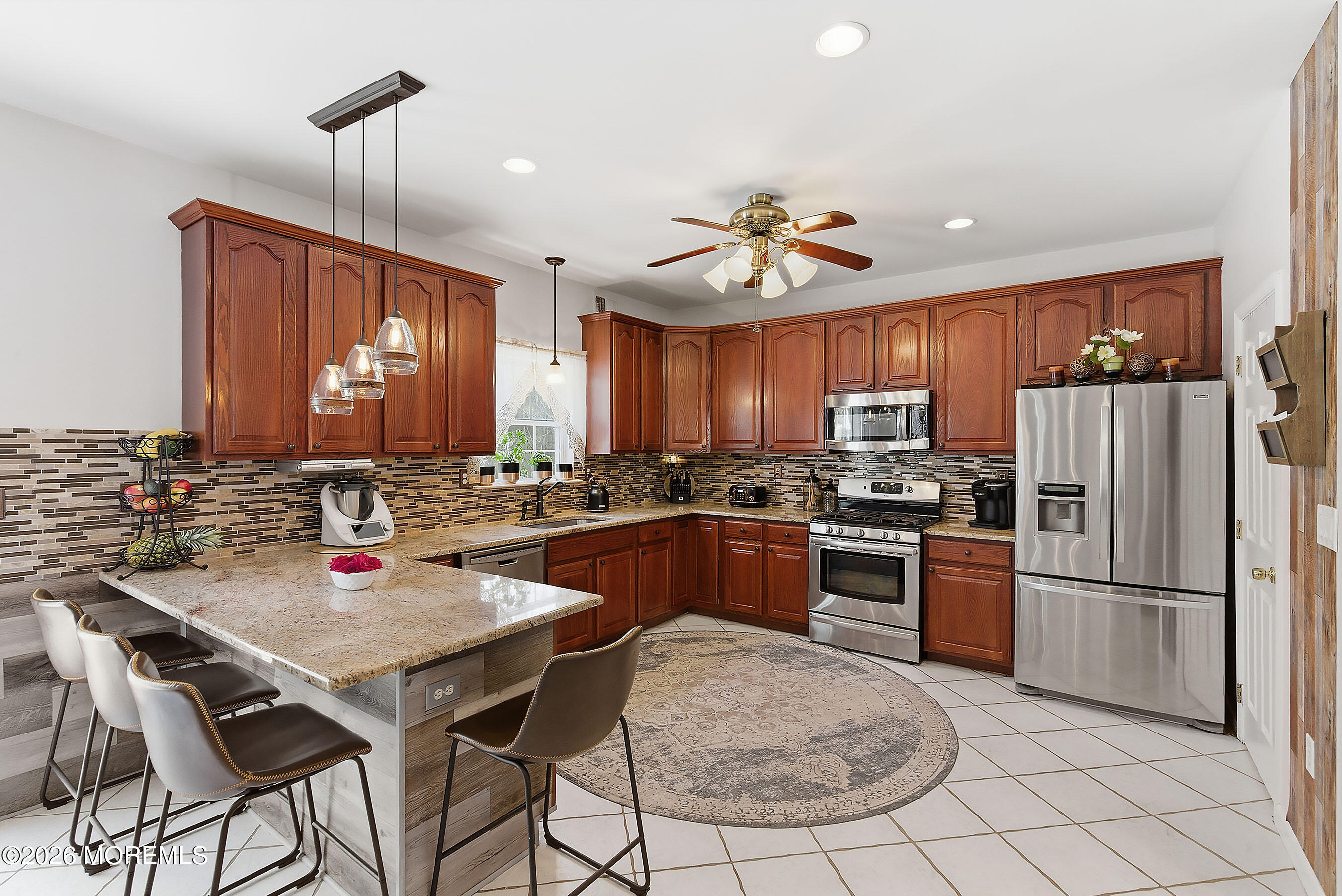 9 Kindling Way Jackson, NJ 08527 - Photo 15 of 33 a kitchen with stainless steel appliances granite countertop a stove a refrigerator a sink a dining table and chairs