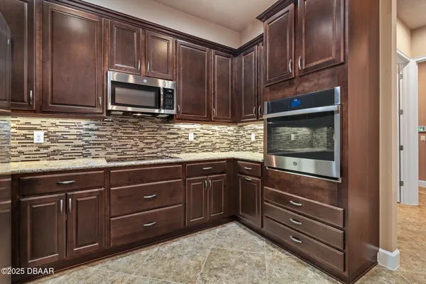 a kitchen with stainless steel appliances granite countertop wooden cabinets and a stove top oven