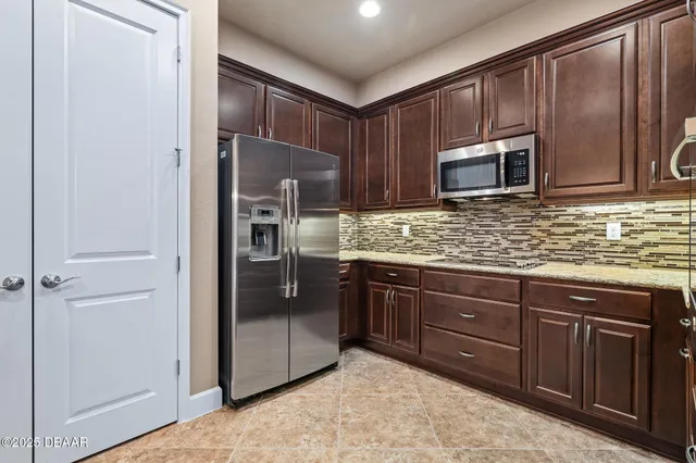 a kitchen with stainless steel appliances granite countertop a refrigerator and a stove top oven