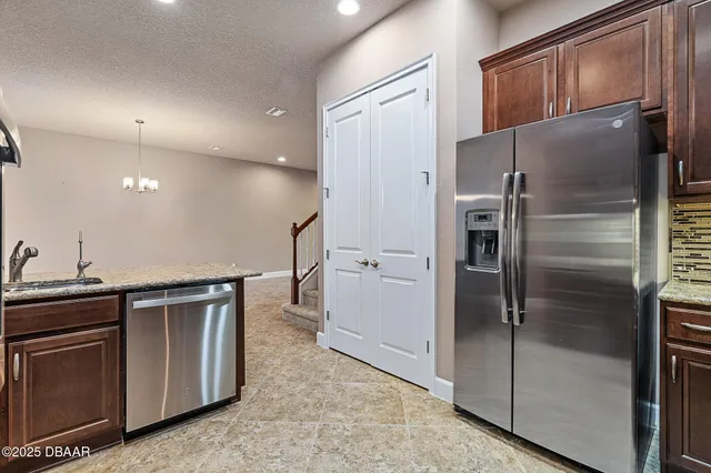 a kitchen with stainless steel appliances granite countertop a refrigerator and a sink