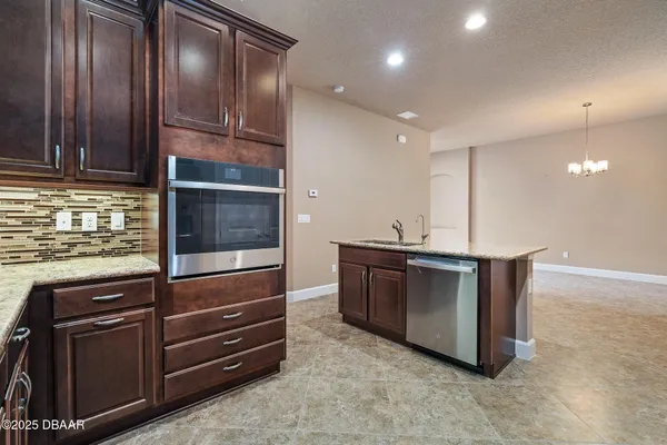 a kitchen with granite countertop stainless steel appliances and wooden cabinets