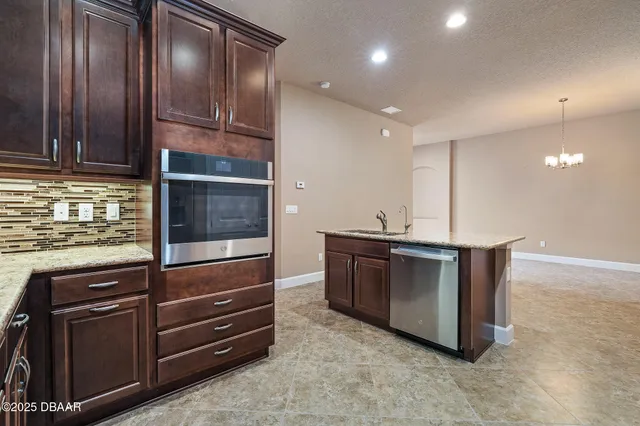 a kitchen with granite countertop stainless steel appliances and wooden cabinets