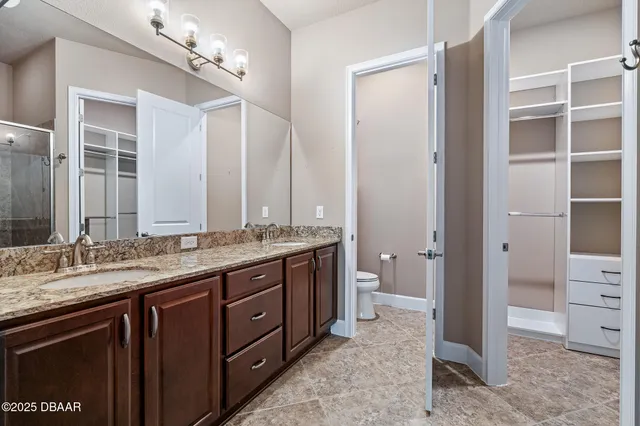 a spacious bathroom with a granite countertop sink a mirror and a shower