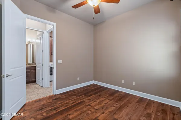 an empty room with closet and a chandelier fan