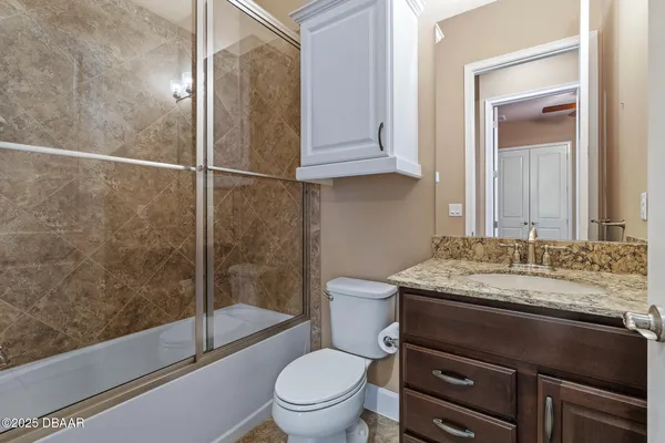 a bathroom with a granite countertop sink toilet and shower
