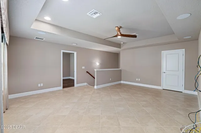 an empty room with ceiling fan and window
