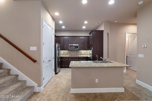 a view of kitchen with kitchen island sink and refrigerator