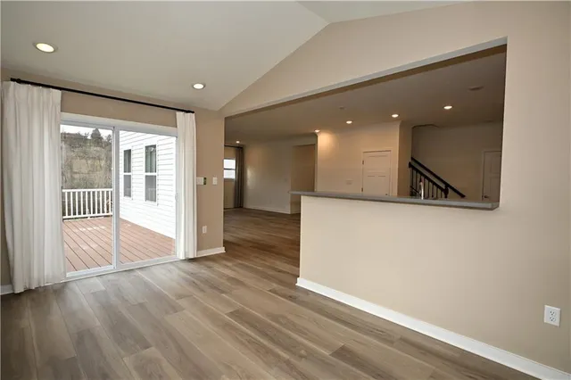 a view of a hallway with wooden floor and a large window