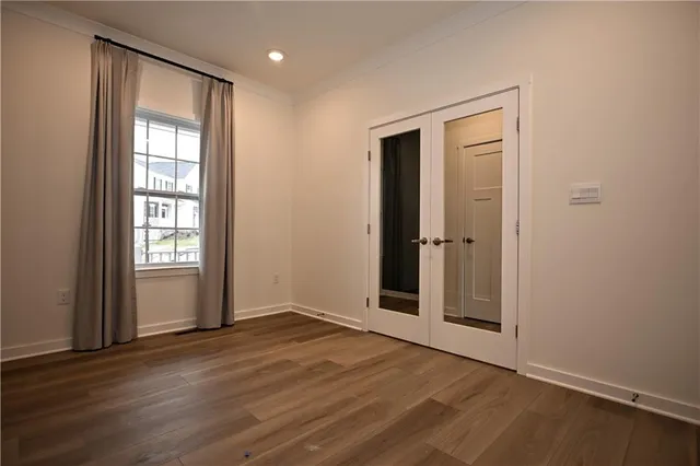 an empty room with wooden floor and a window