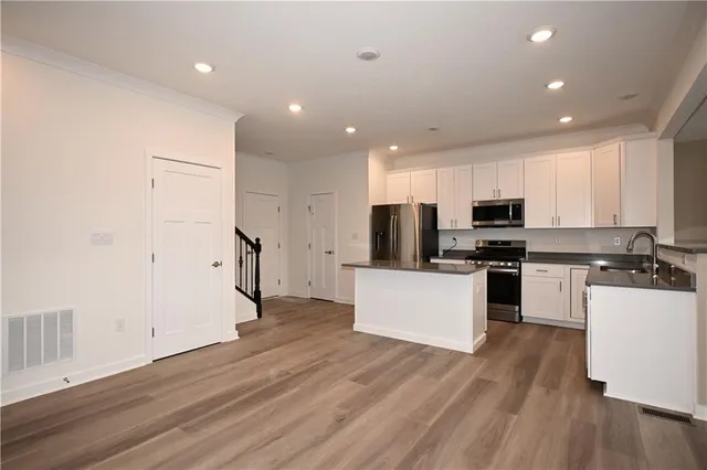 a kitchen with stainless steel appliances a refrigerator and a stove top oven