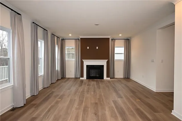 wooden floor fireplace and windows in an empty room