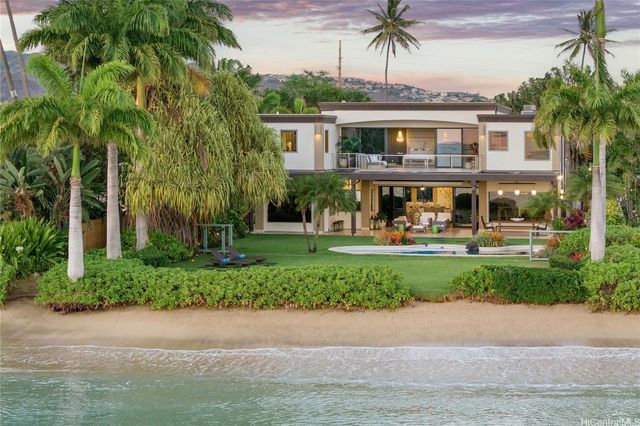 a front view of a house with a yard and potted plants
