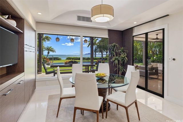 a dining room with furniture a flat screen tv and a floor to ceiling window