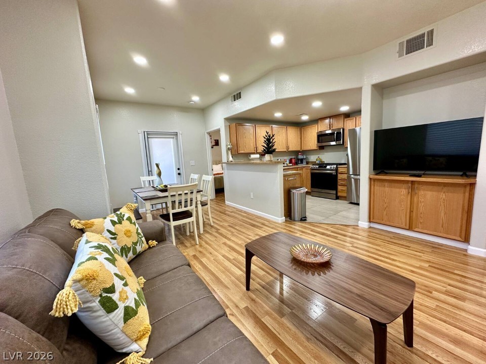 9580 West Reno Avenue, Unit 169 Las Vegas, NV 89148 - Photo 15 of 15 An open floorplan seamlessly connects the well-appointed kitchen, dining area, and living space with warm wood flooring.