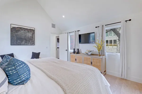 a spacious bedroom with a bed and a chair