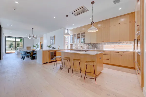 a kitchen with kitchen island a dining table chairs sink and cabinets