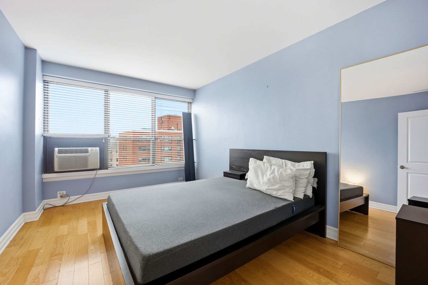 2930 North Sheridan Road, Unit 1912 Chicago, IL 60657 - Photo 16 of 25 a bed sitting in a bedroom next to a window