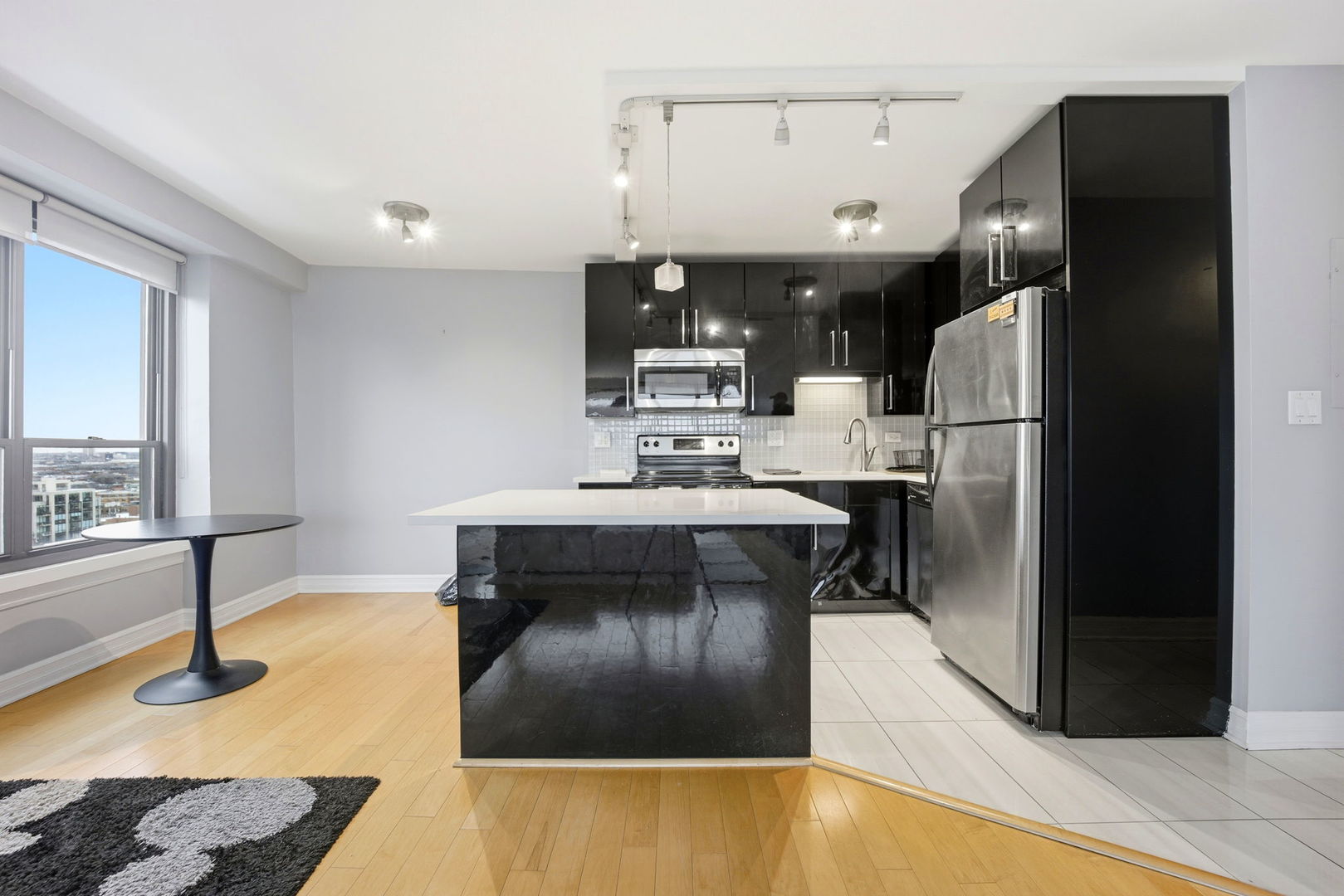 2930 North Sheridan Road, Unit 1912 Chicago, IL 60657 - Photo 8 of 25 a kitchen with stainless steel appliances granite countertop a sink a stove and a refrigerator