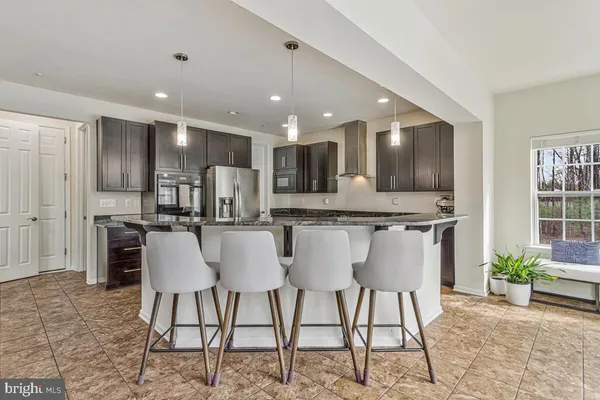 a kitchen with stainless steel appliances granite countertop a refrigerator a sink and a stove