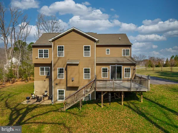 a view of house with deck and wooden fence