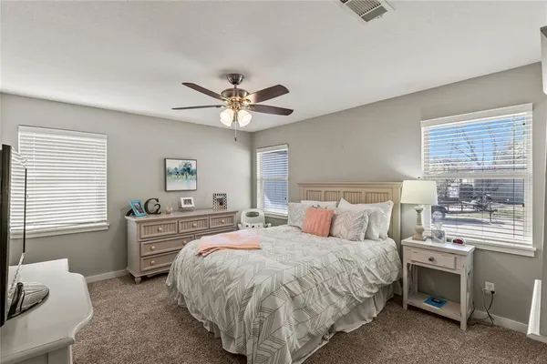 a spacious bedroom with a bed and a chandelier