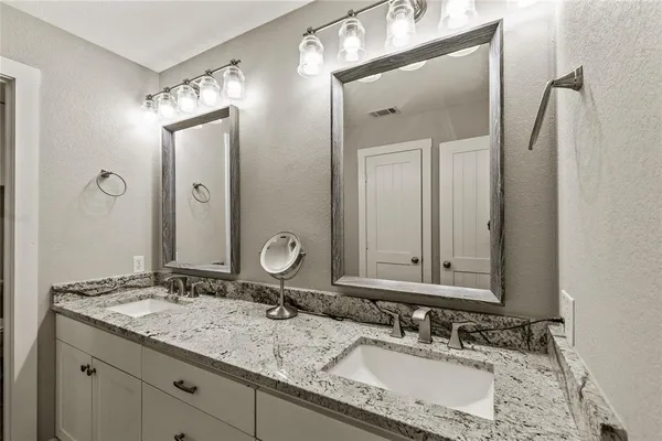 a bathroom with a granite countertop sink double and mirror