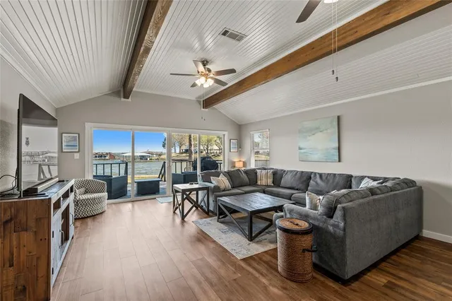 a living room with furniture ceiling fan and a large window
