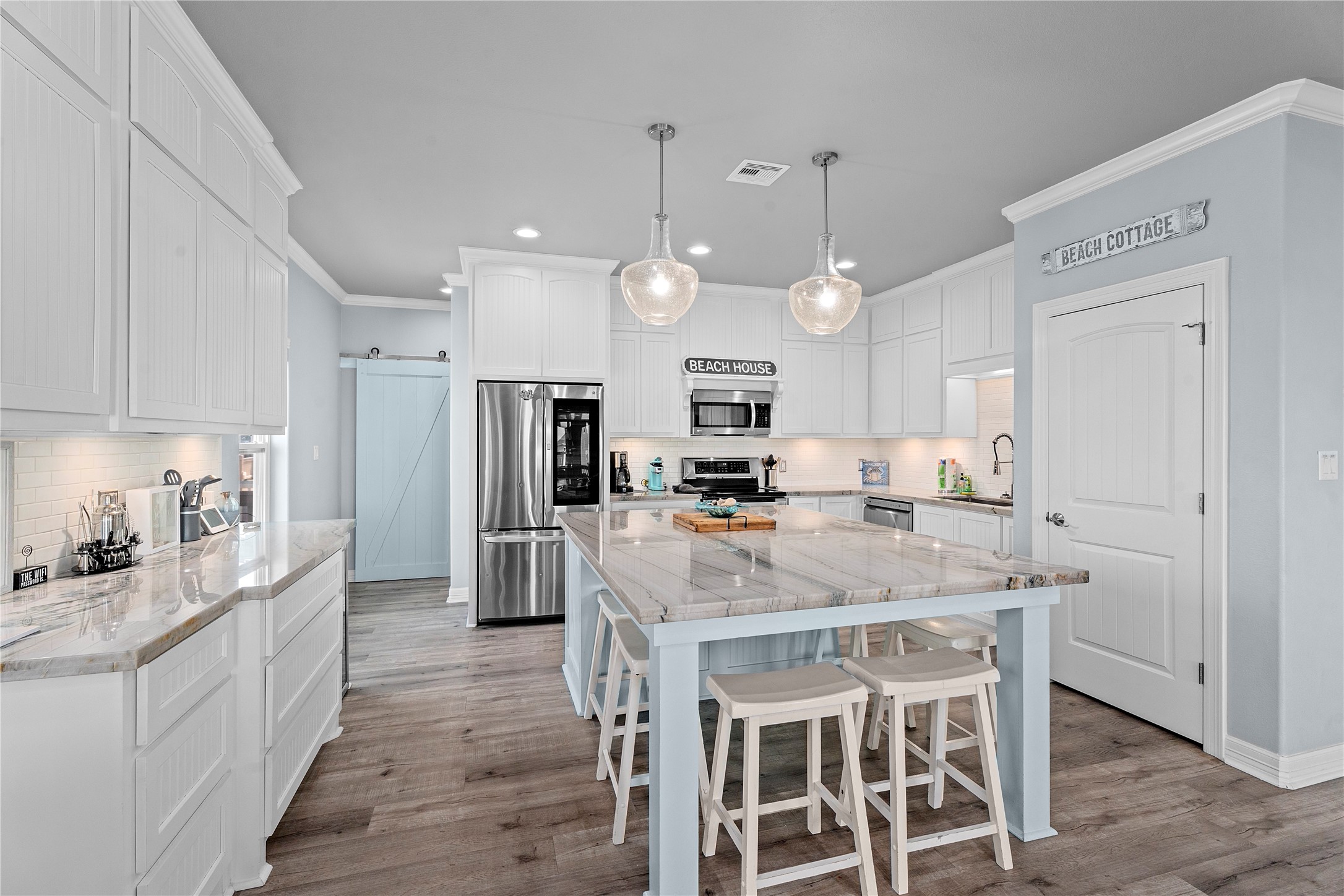941 South Gateway Road Crystal Beach, TX 77650 - Photo 11 of 43 a kitchen with stainless steel appliances kitchen island granite countertop a table chairs refrigerator and microwave