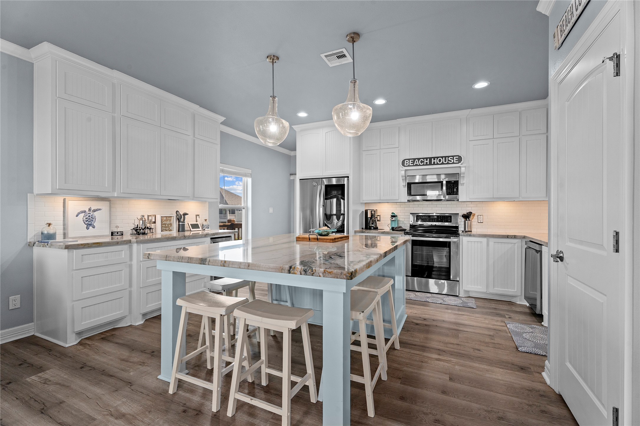 941 South Gateway Road Crystal Beach, TX 77650 - Photo 9 of 43 a kitchen with kitchen island granite countertop a center island and stainless steel appliances