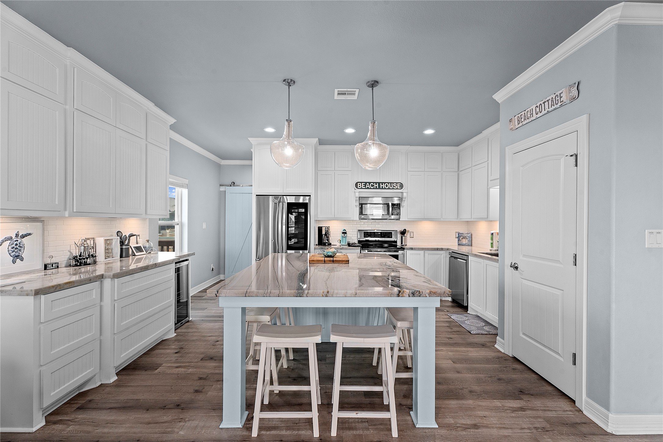 941 South Gateway Road Crystal Beach, TX 77650 - Photo 10 of 43 a kitchen with stainless steel appliances kitchen island granite countertop a table chairs refrigerator and sink