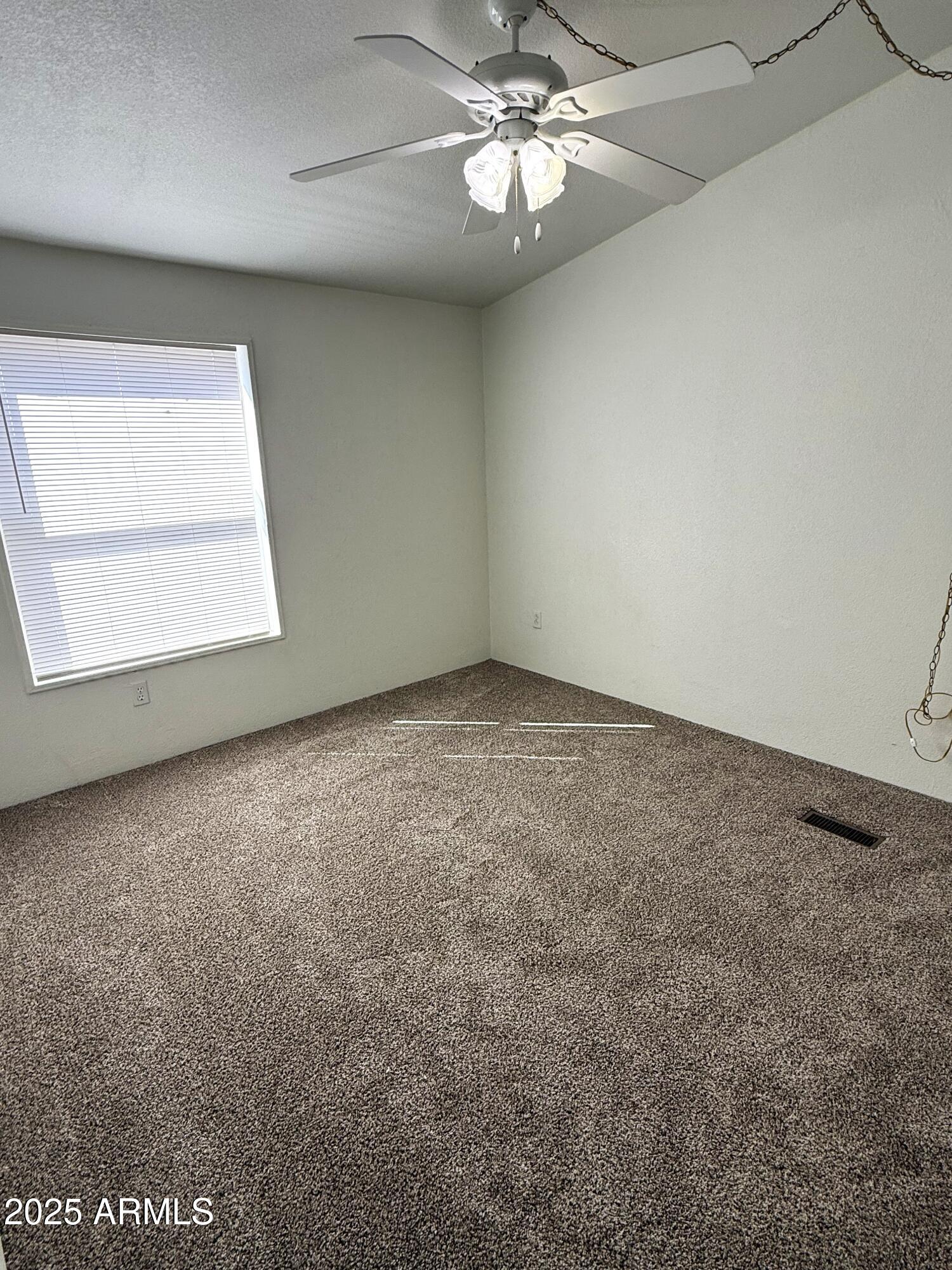 7672 Mesa Vista Payson, AZ 85541 - Photo 13 of 24 en empty room with windows and chandelier fan
