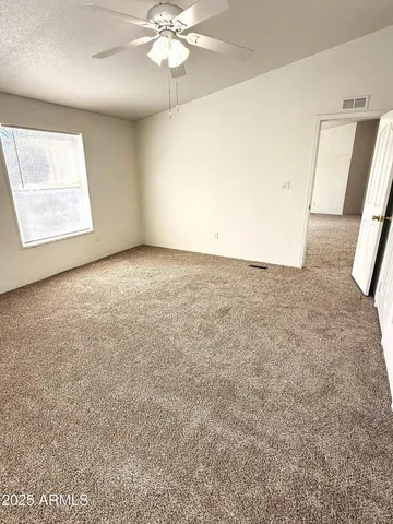 en empty room with windows and ceiling fan