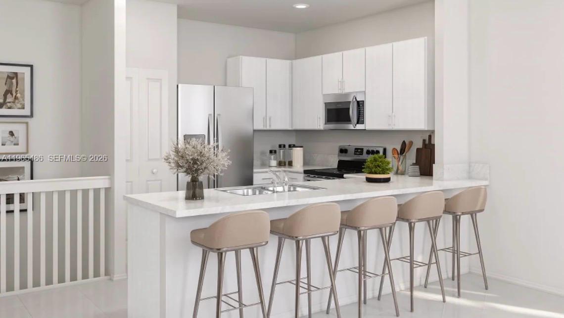 12470 Southwest 248th Street, Unit 1 Homestead, FL 33032 - Photo 11 of 35 a kitchen with stainless steel appliances kitchen island granite countertop a sink and cabinets