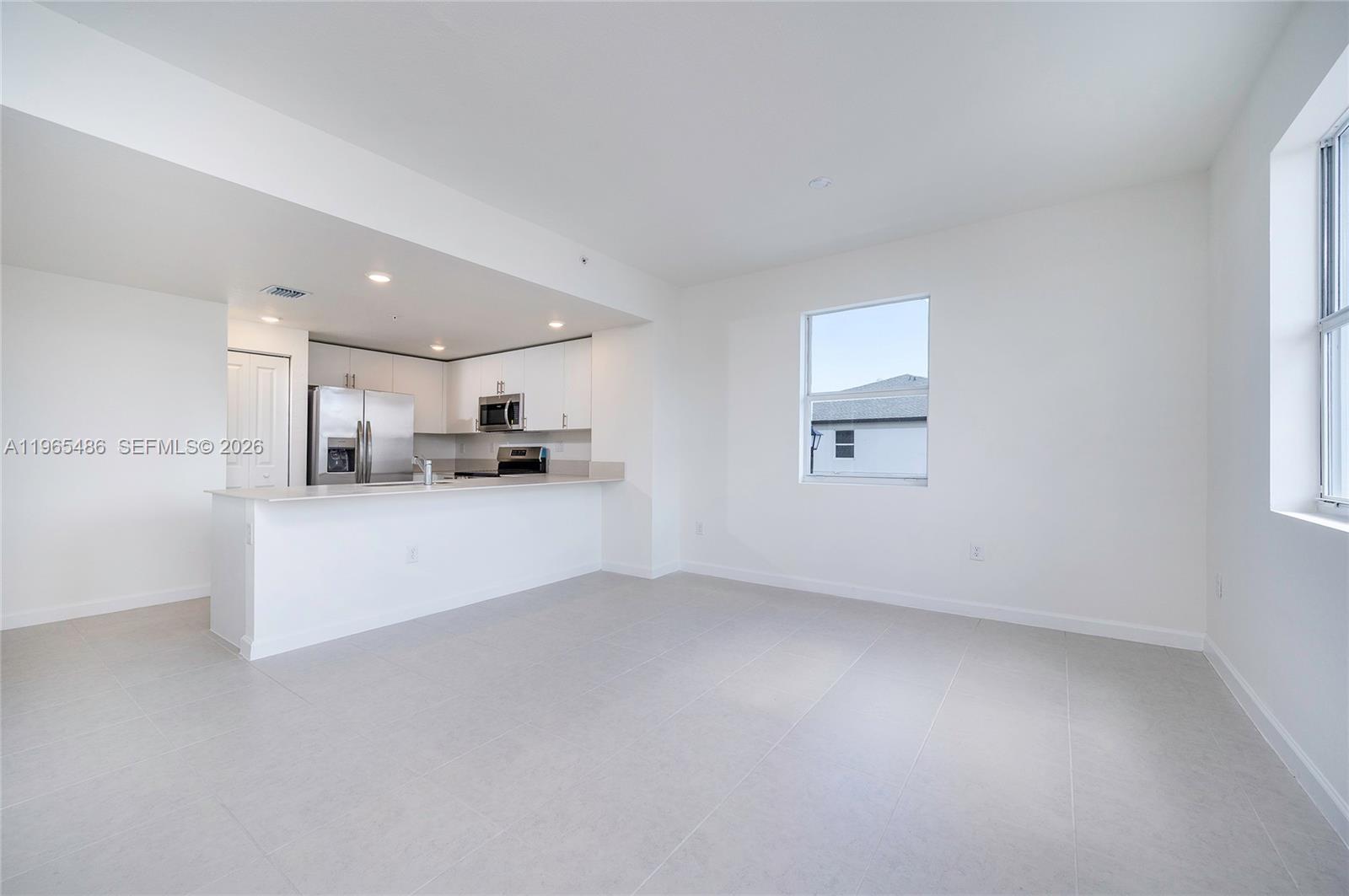 12470 Southwest 248th Street, Unit 1 Homestead, FL 33032 - Photo 13 of 35 a view of kitchen with kitchen island white cabinets and refrigerator