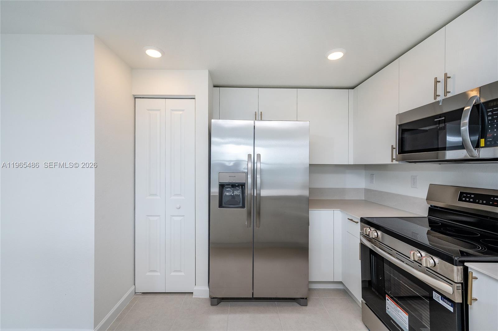 12470 Southwest 248th Street, Unit 1 Homestead, FL 33032 - Photo 10 of 35 a kitchen with stainless steel appliances granite countertop a refrigerator a stove and a microwave