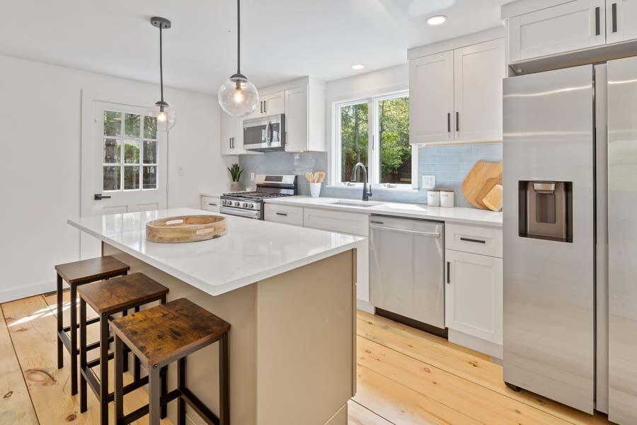84 Cap'n Lijah's Road Centerville, MA 02632 - Photo 11 of 24 a kitchen with a table chairs and cabinets