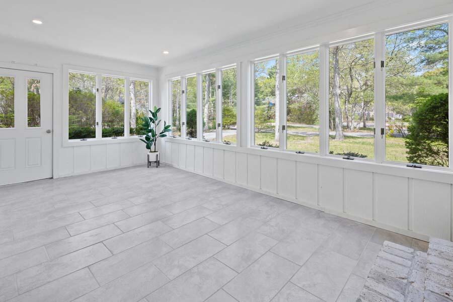 84 Cap'n Lijah's Road Centerville, MA 02632 - Photo 5 of 24 a large white kitchen with large windows and sink