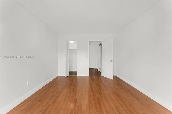 a view of empty room with wooden floor