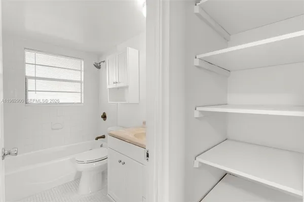 a bathroom with a toilet sink a bathtub and next to a window