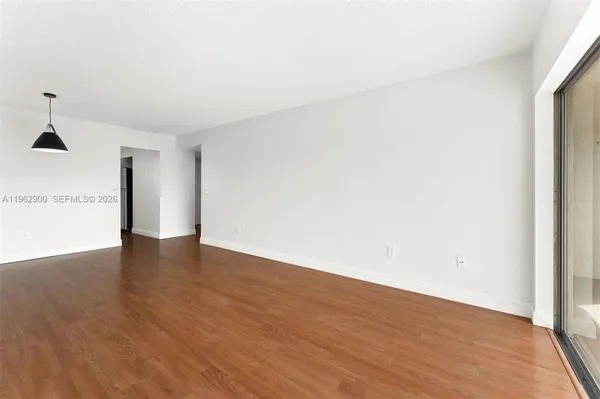 a view of an empty room with wooden floor