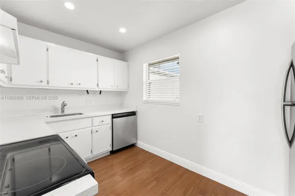 a kitchen with granite countertop white cabinets and white appliances