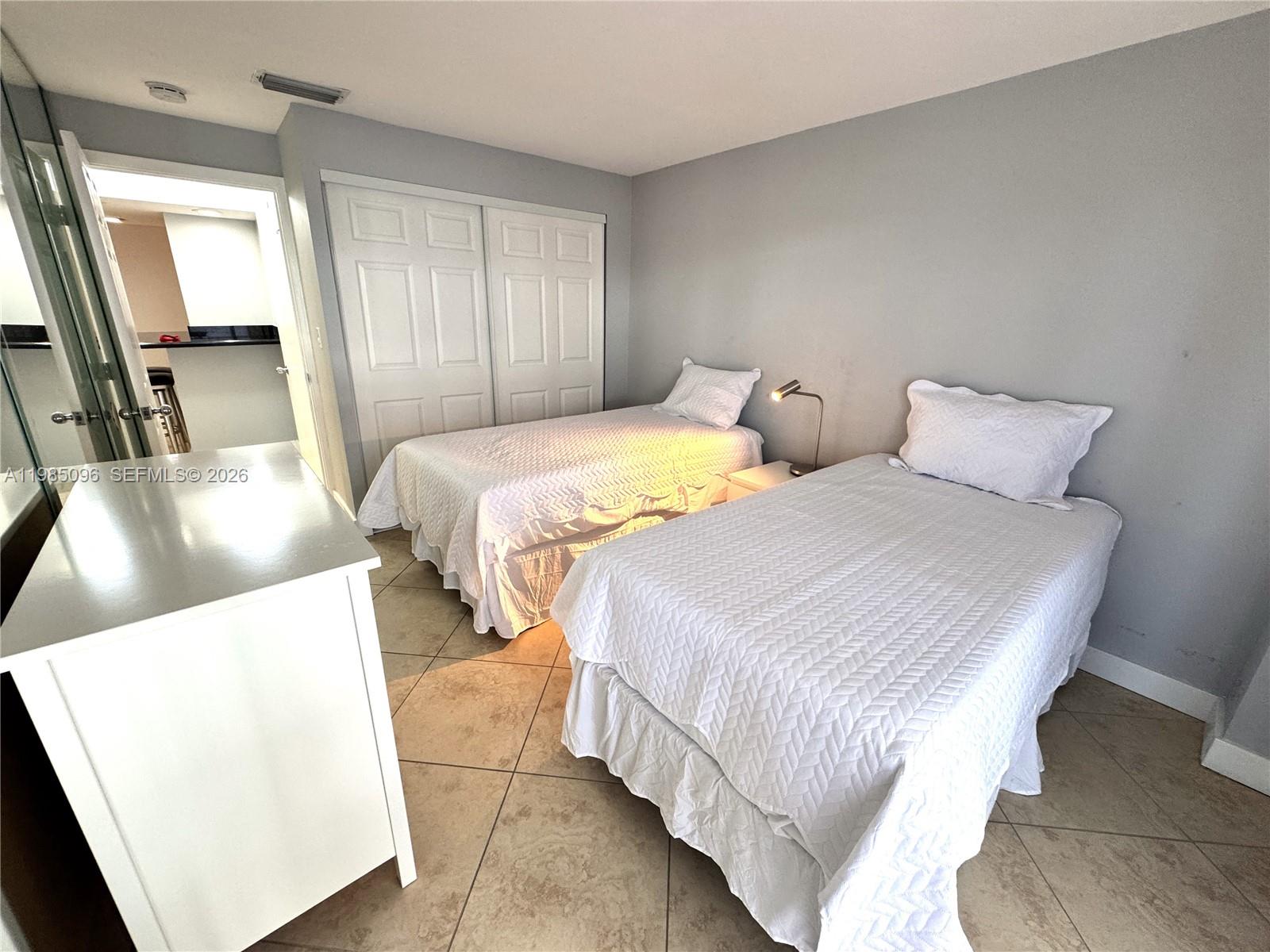 9195 Collins Avenue, Unit PH4 Surfside, FL 33154 - Photo 11 of 22 a bedroom with beds and a large mirror next to a window