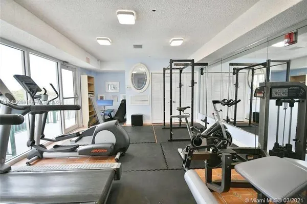 a living room with furniture a flat screen tv and large windows