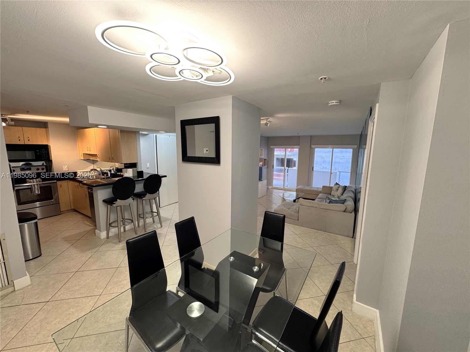 9195 Collins Avenue, Unit PH4 Surfside, FL 33154 - Photo 3 of 22 a view of a dining room with furniture and a chandelier