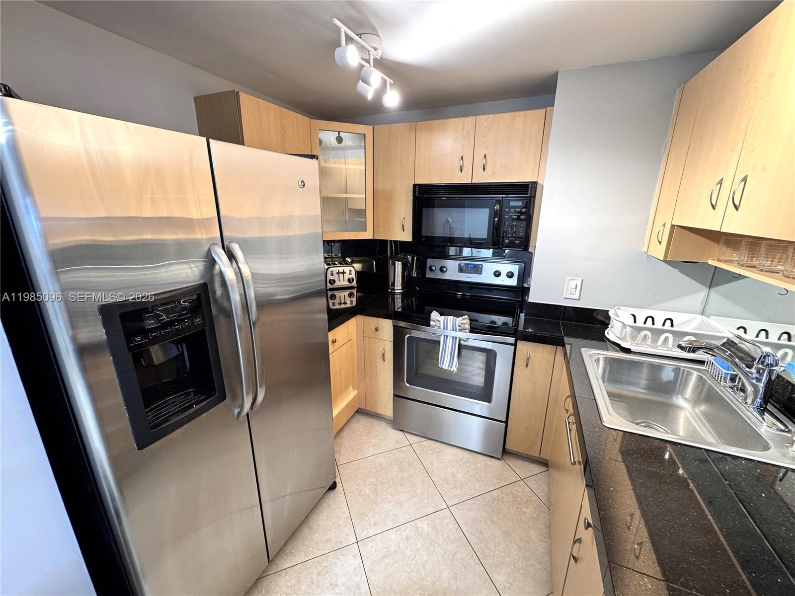9195 Collins Avenue, Unit PH4 Surfside, FL 33154 - Photo 5 of 22 a kitchen with stainless steel appliances granite countertop a refrigerator stove and sink