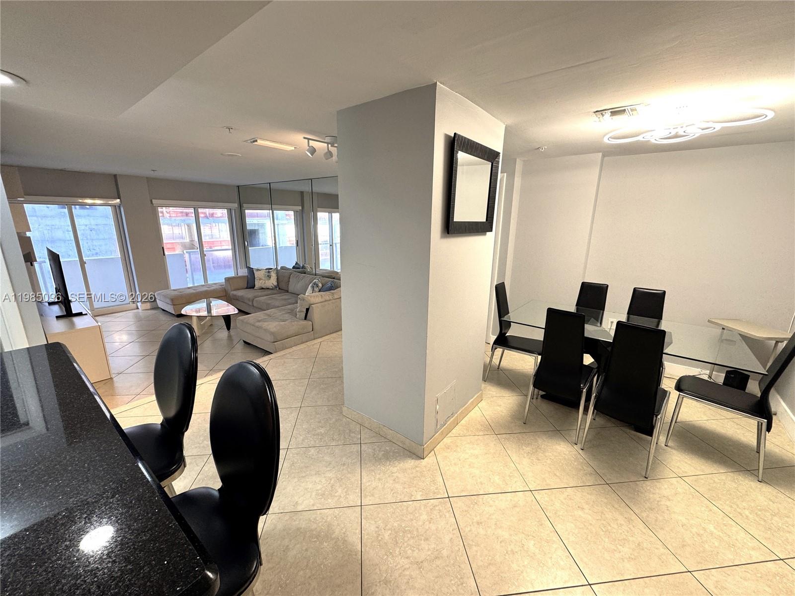 9195 Collins Avenue, Unit PH4 Surfside, FL 33154 - Photo 6 of 22 a view of kitchen with sink dining table and chairs